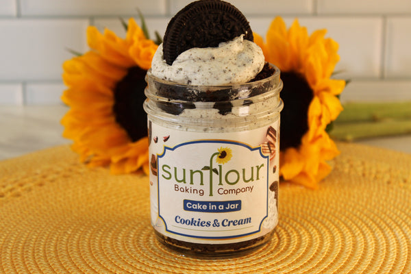 Sunflour Baking Company’s Cookies and Cream Cake Jar with cookies and cream frosting, sunflowers in the background.